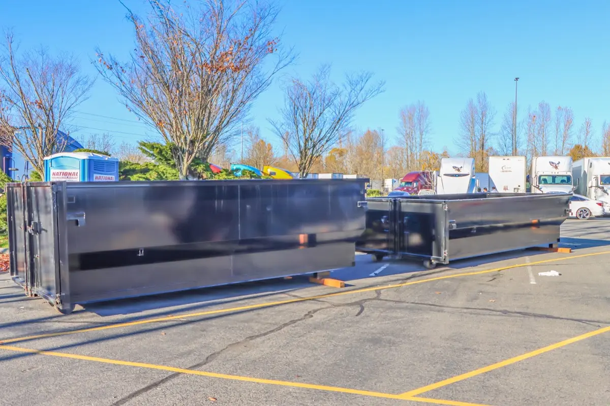 Professional dumpster rental service with roll-off container on residential driveway in Gilford